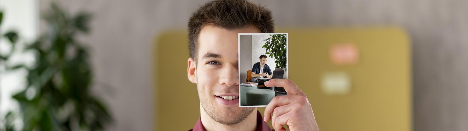 Junger Kollege ist Student und lernt und hält ein Bild wo er bald gestalten kann.