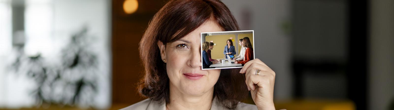 Frau hält Bild von morgen in der Hand.