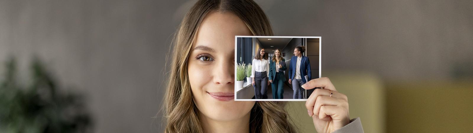 Frau hält Foto in Hand mit Projektleitung