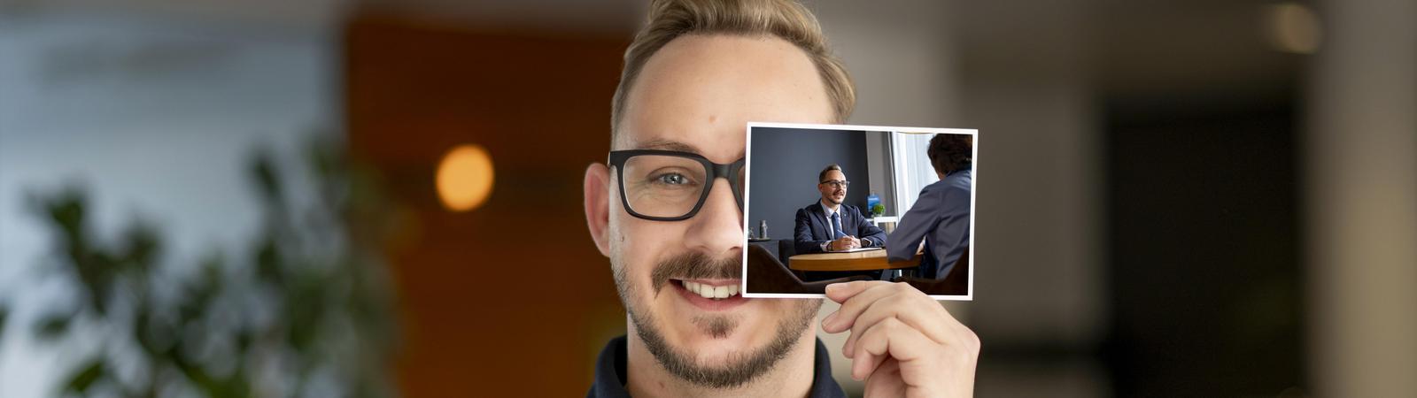 Mann hält Foto in Hand mit Kundenberatung