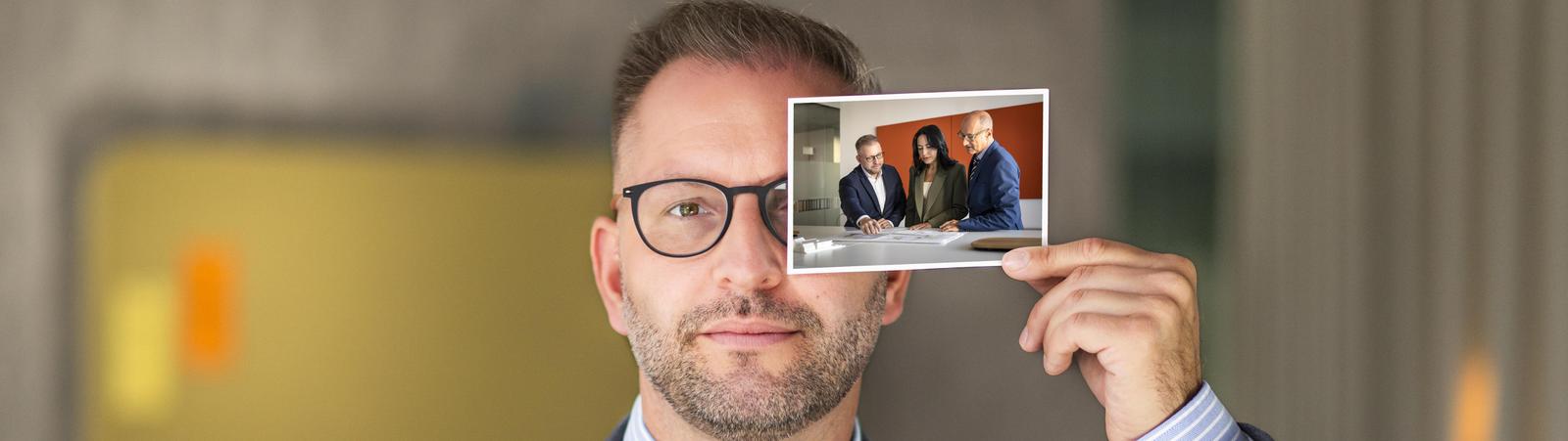 Mann hält Foto in Hand mit Kundenberatung